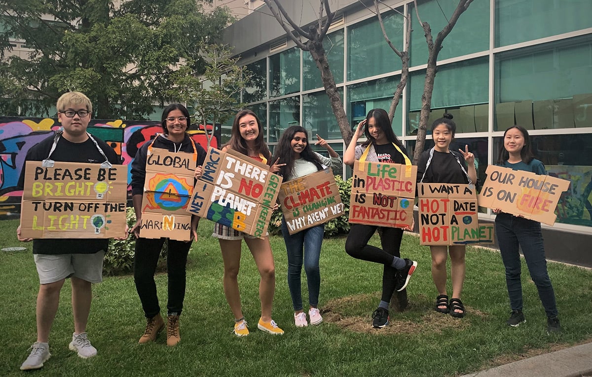 A group of students with placards bearing sustainability messages