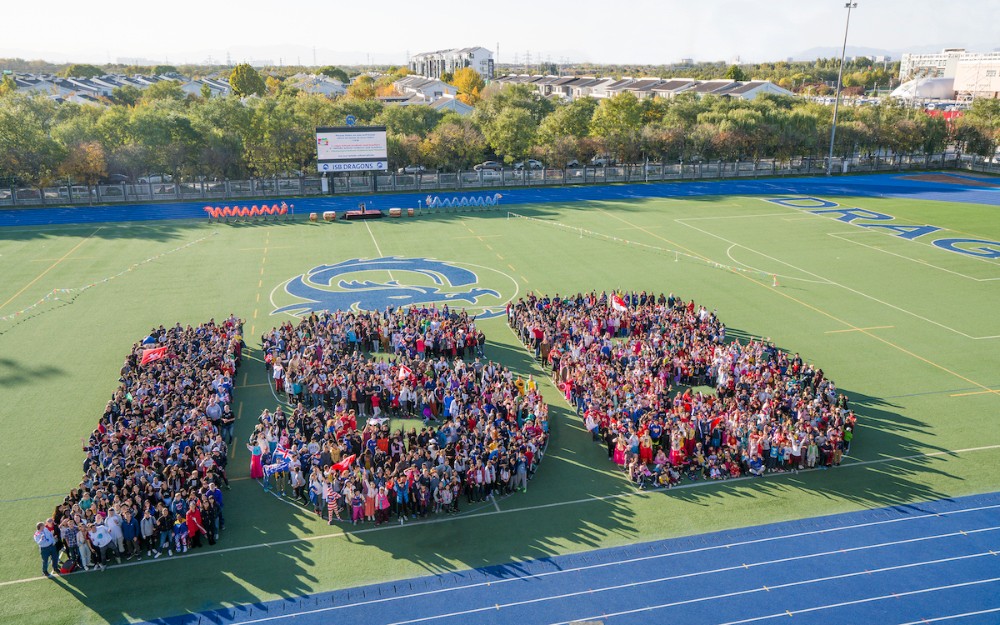 An overhead shot of a large group of people in formation to read "ISB"