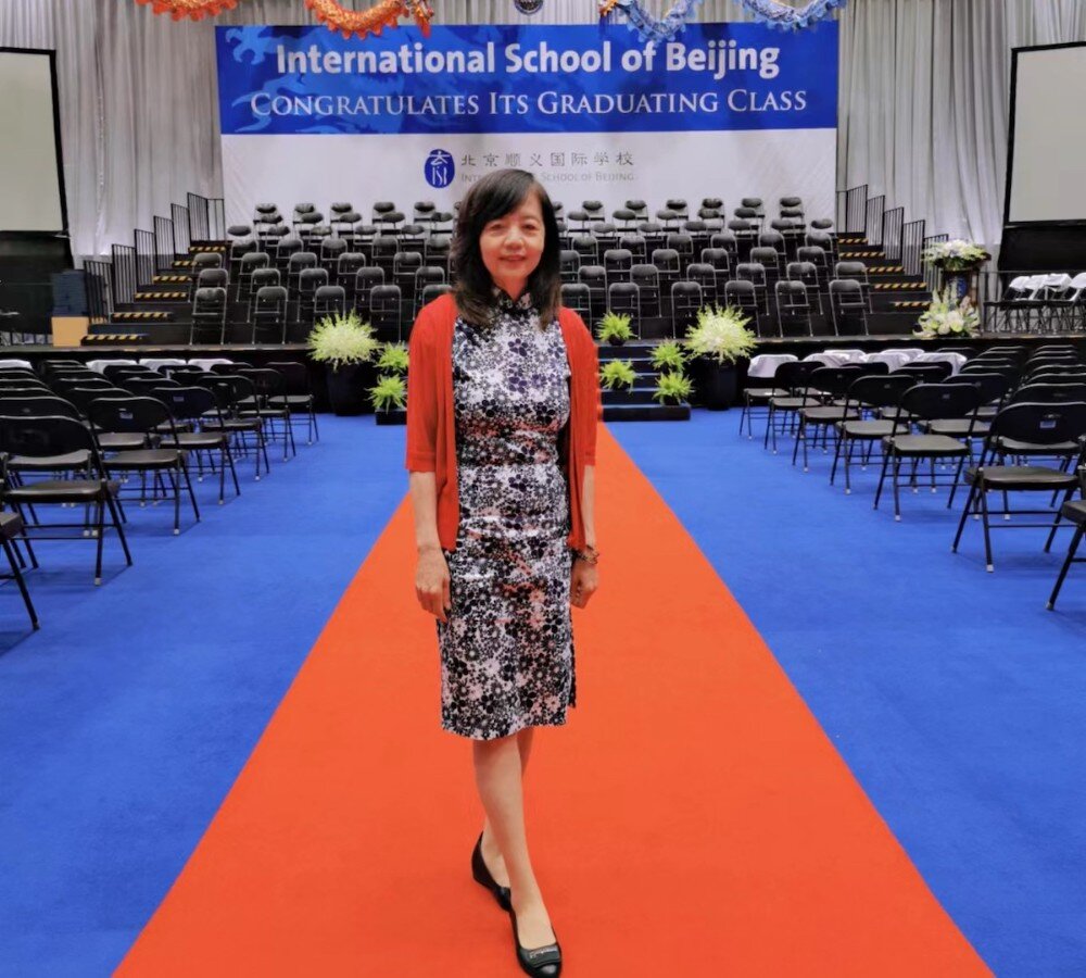 Xiu Mei Zhang in a theater decorated for a graduation ceremony