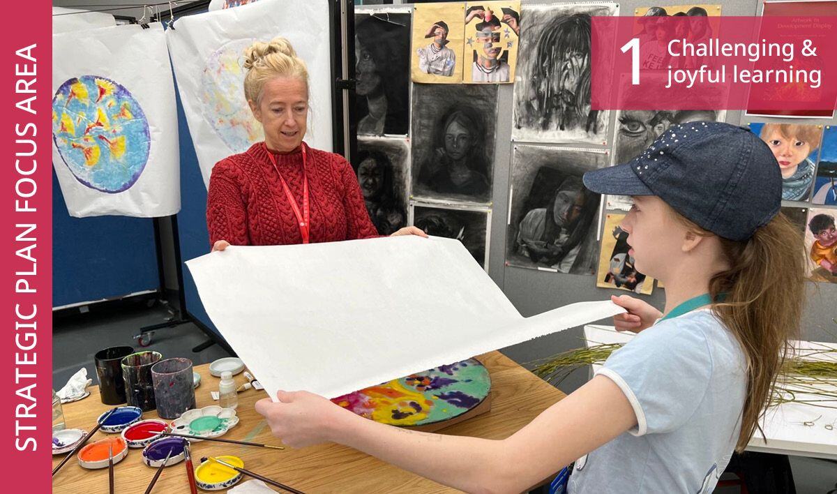 Two people unfurling a canvas in an ISB art studio