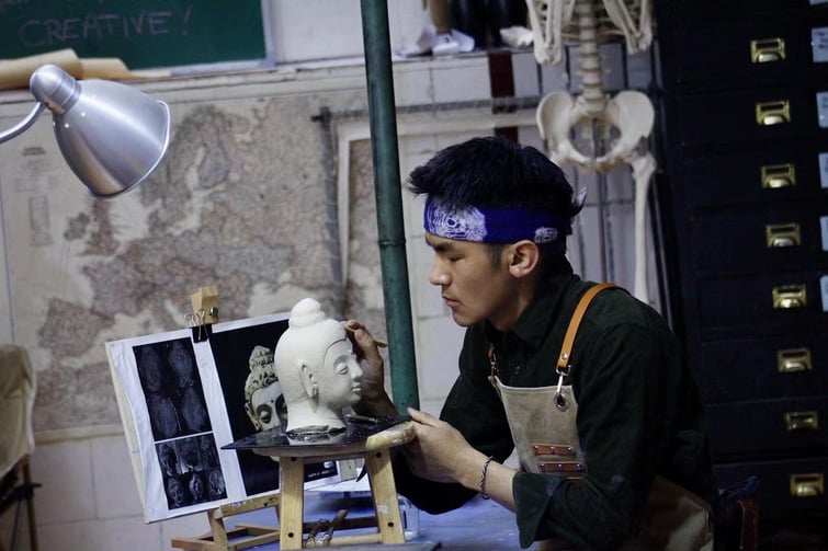 A sculptor working in an ISB art studio