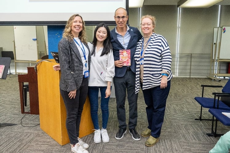 Alumni author Amélie Wen Zhao poses with librarians and Head of School Daniel Rubenstein